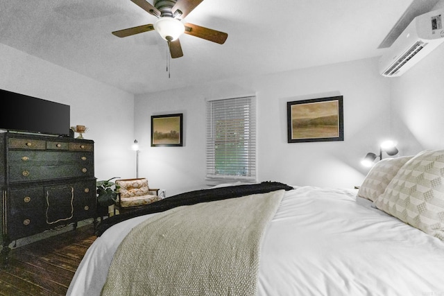 bedroom featuring dark wood-type flooring, ceiling fan, and a wall mounted air conditioner