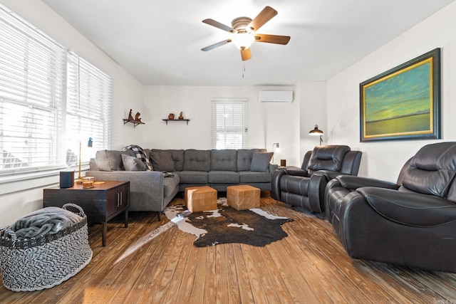 living room with ceiling fan, a healthy amount of sunlight, wood-type flooring, and an AC wall unit