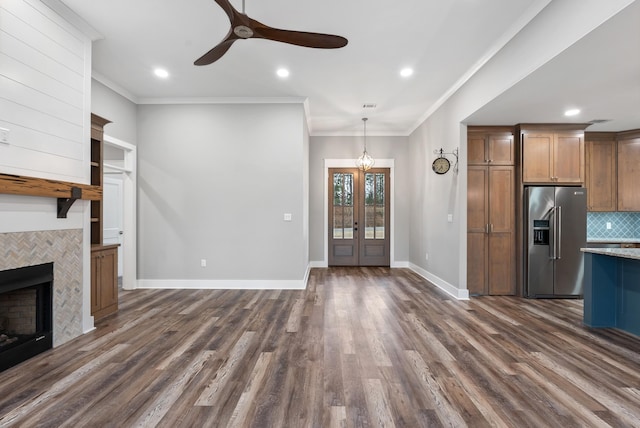 kitchen with dark hardwood / wood-style floors, ornamental molding, a tiled fireplace, decorative backsplash, and high end refrigerator