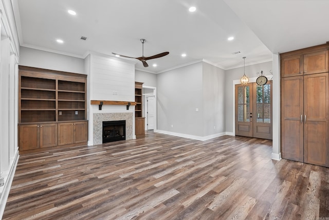 unfurnished living room with ornamental molding, dark hardwood / wood-style floors, a fireplace, and ceiling fan