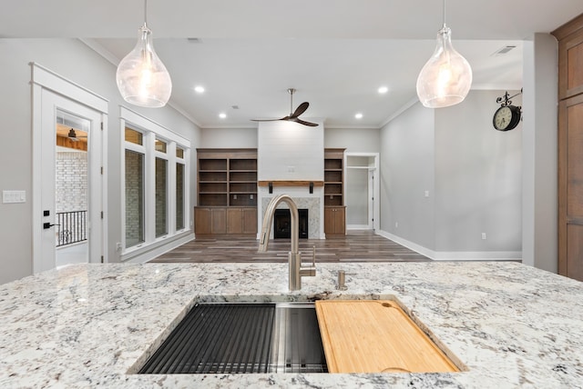 kitchen with hardwood / wood-style flooring, crown molding, pendant lighting, and ceiling fan