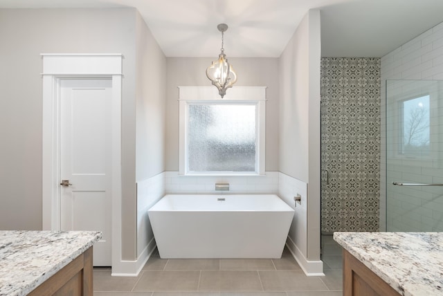 bathroom with vanity, tile patterned floors, shower with separate bathtub, and tile walls