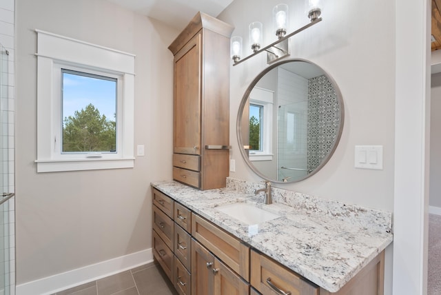 bathroom featuring a shower with door, vanity, and tile patterned floors