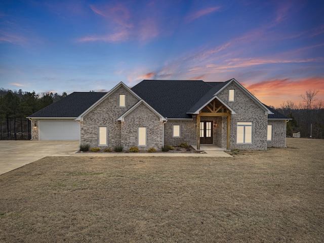 view of front facade with a yard and a garage