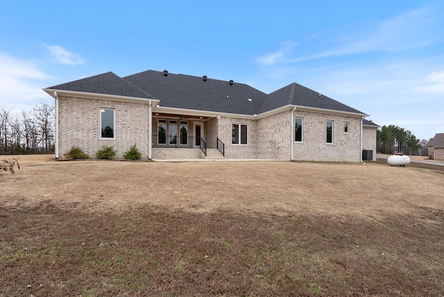 back of property featuring a yard, central AC unit, and a patio area