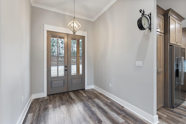 entryway featuring dark wood-type flooring, ornamental molding, french doors, and a notable chandelier