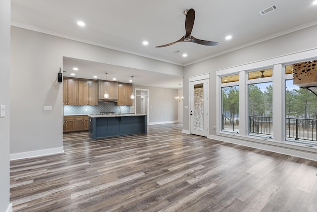 kitchen with crown molding, a center island, hanging light fixtures, and backsplash