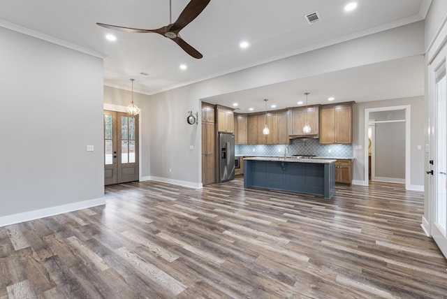 kitchen with hanging light fixtures, a kitchen island, high end fridge, and decorative backsplash