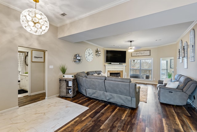 living room with ceiling fan with notable chandelier, ornamental molding, and hardwood / wood-style floors