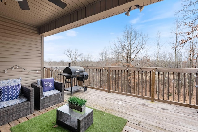 wooden terrace with an outdoor living space, ceiling fan, and a grill