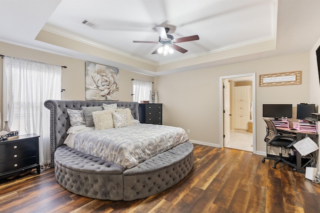 bedroom featuring dark hardwood / wood-style flooring, ornamental molding, and a raised ceiling