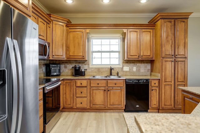 kitchen featuring appliances with stainless steel finishes, tasteful backsplash, sink, crown molding, and light hardwood / wood-style flooring