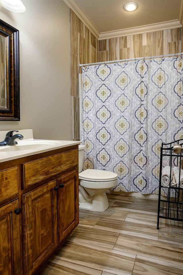 bathroom with ornamental molding, toilet, vanity, and a textured ceiling