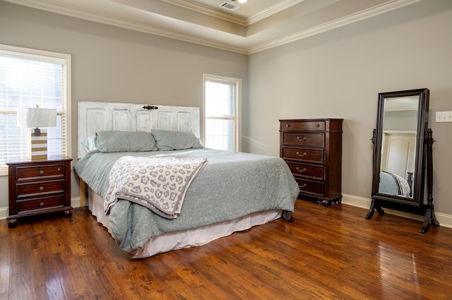 bedroom with ornamental molding, dark hardwood / wood-style flooring, and a raised ceiling