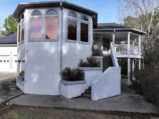 view of home's exterior with a garage and covered porch