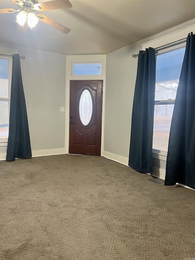 carpeted foyer with a healthy amount of sunlight and ceiling fan
