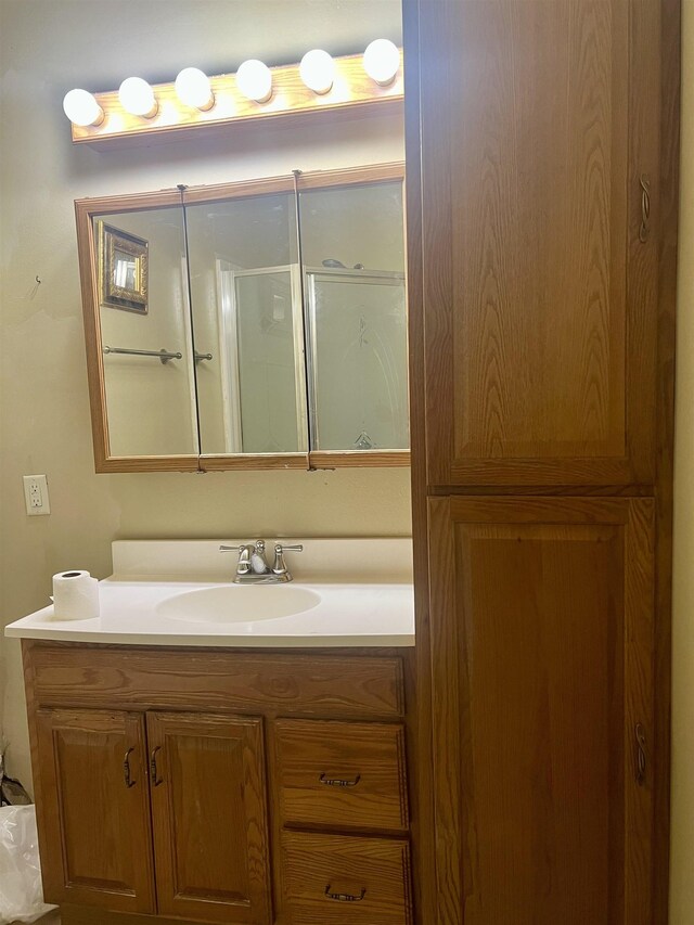 bathroom with vanity and a shower with door