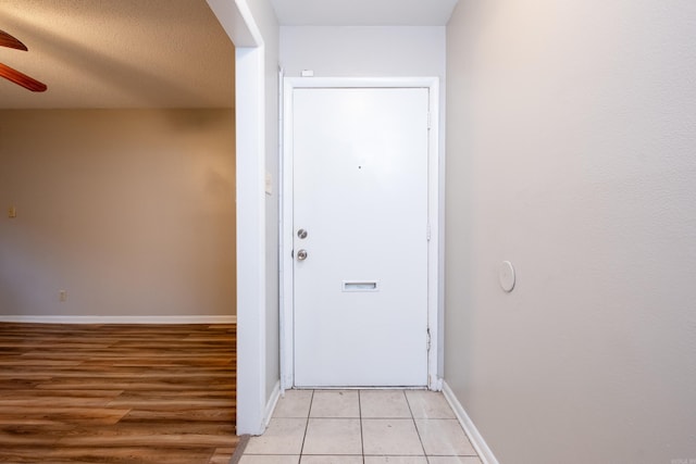 doorway to outside featuring ceiling fan and light tile patterned floors