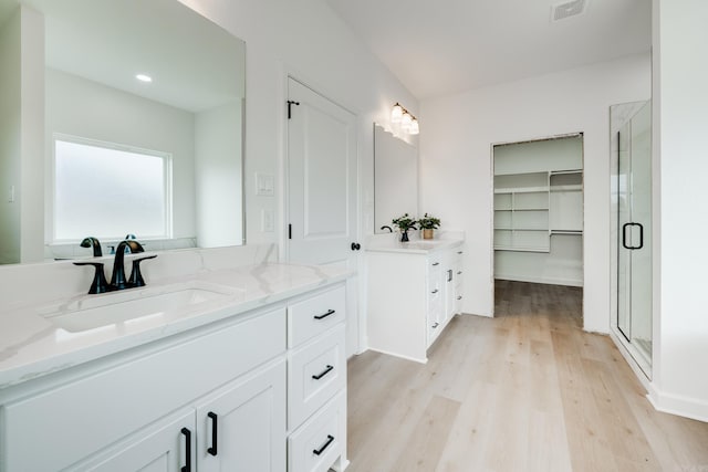 bathroom with vanity, wood-type flooring, and a shower with door