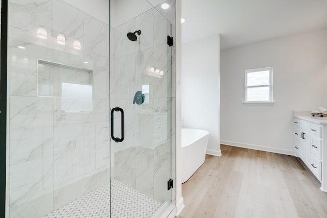 bathroom with hardwood / wood-style flooring, vanity, and independent shower and bath