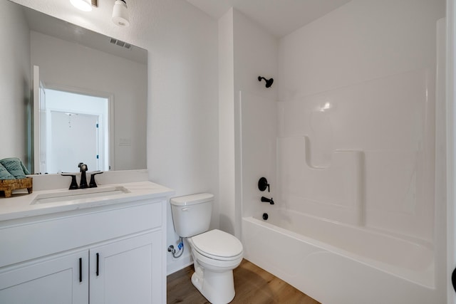 full bathroom featuring vanity, tub / shower combination, hardwood / wood-style floors, and toilet