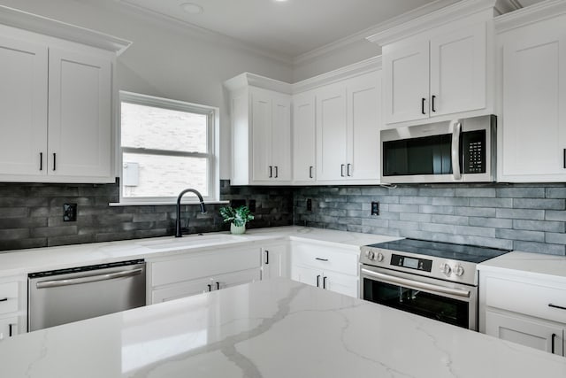 kitchen featuring stainless steel appliances, white cabinetry, sink, and ornamental molding