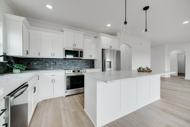 kitchen with white cabinetry, appliances with stainless steel finishes, a center island, and pendant lighting