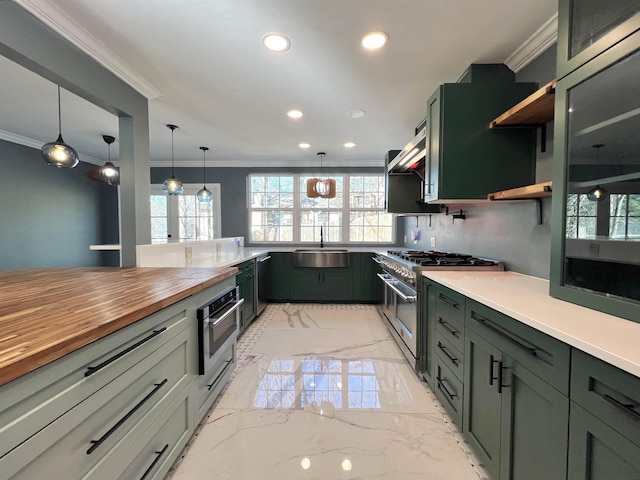 kitchen featuring crown molding, stainless steel appliances, sink, and hanging light fixtures