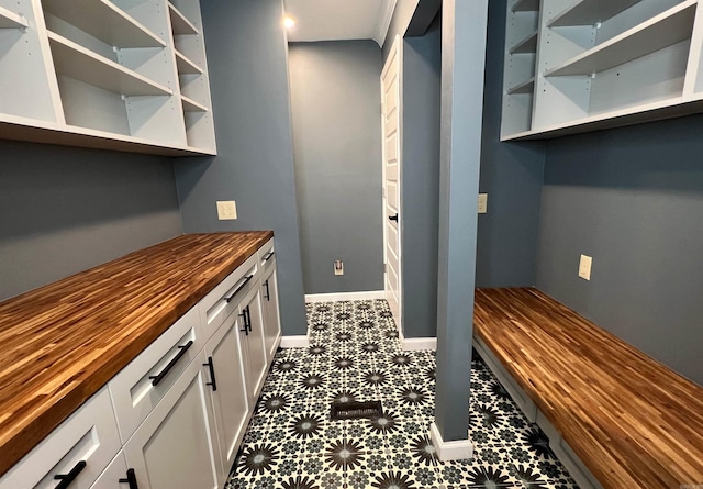 interior space with white cabinetry and butcher block counters