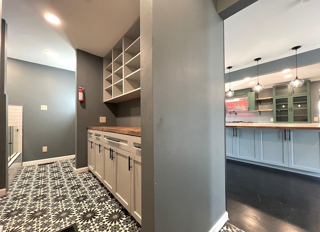 kitchen with white cabinetry, butcher block countertops, and decorative light fixtures