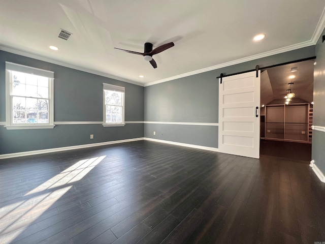 spare room with crown molding, dark hardwood / wood-style floors, a barn door, and ceiling fan