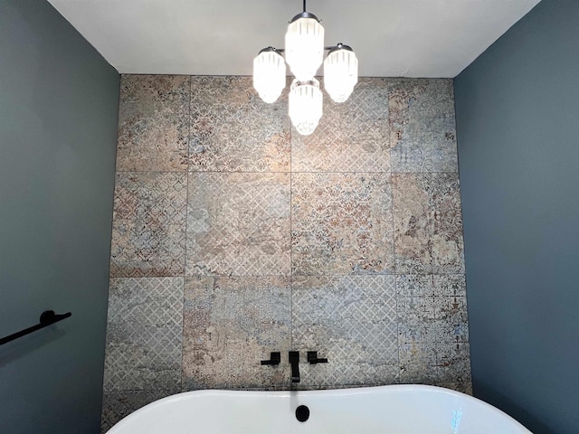 bathroom with a tub and a notable chandelier