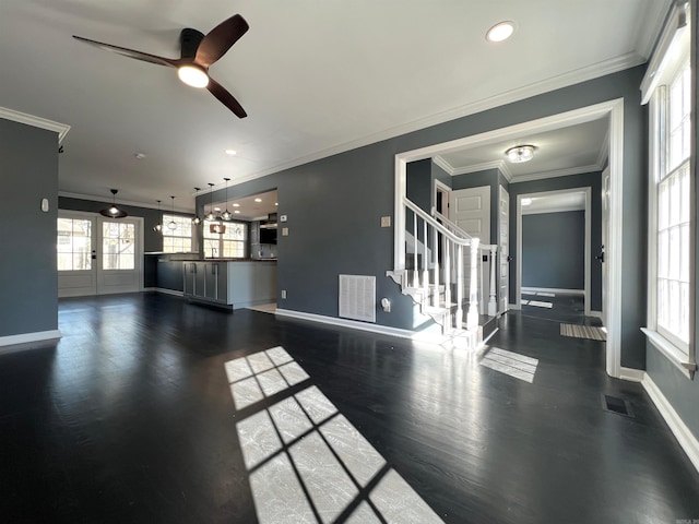 unfurnished living room featuring ornamental molding, a healthy amount of sunlight, and dark hardwood / wood-style flooring