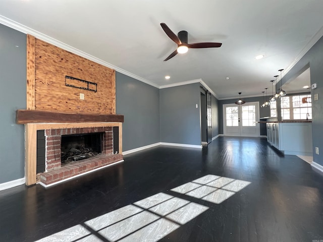 unfurnished living room with dark hardwood / wood-style flooring, a brick fireplace, crown molding, and ceiling fan