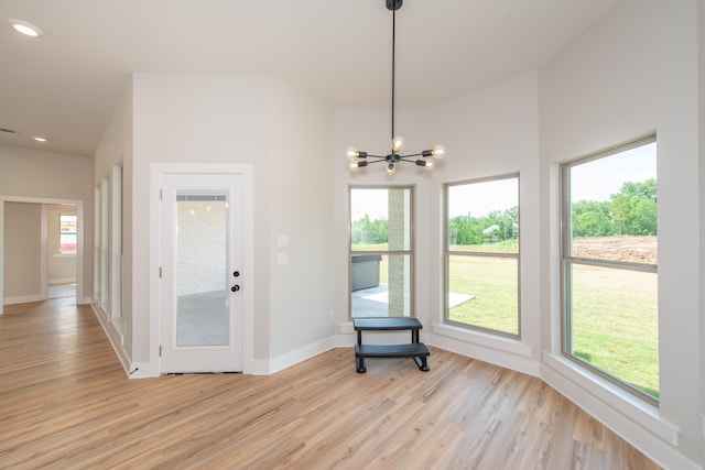 unfurnished room featuring light hardwood / wood-style flooring and a notable chandelier