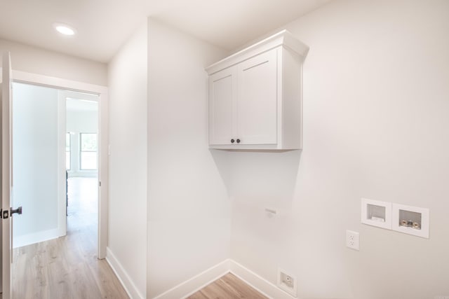 laundry room with cabinets, washer hookup, and light hardwood / wood-style floors