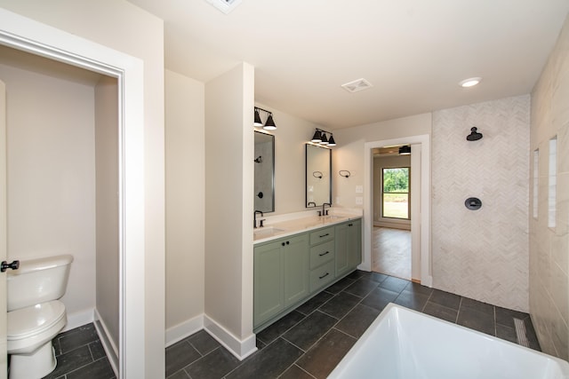 bathroom with vanity, a tub, and toilet