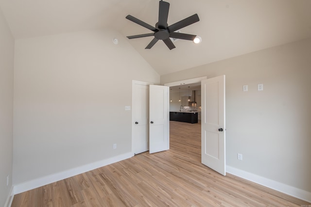 empty room featuring high vaulted ceiling, light hardwood / wood-style floors, and ceiling fan