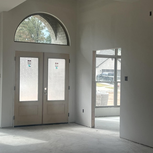 foyer entrance featuring french doors and a towering ceiling