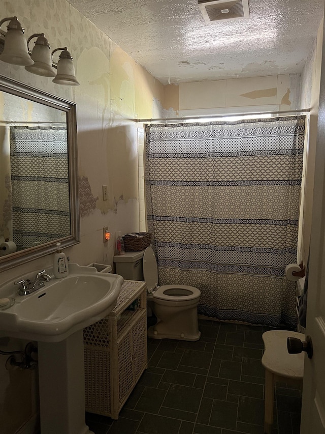 bathroom featuring a shower with curtain, a textured ceiling, and toilet