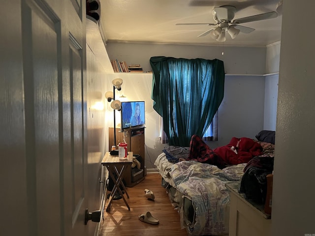 bedroom with crown molding, ceiling fan, and hardwood / wood-style floors