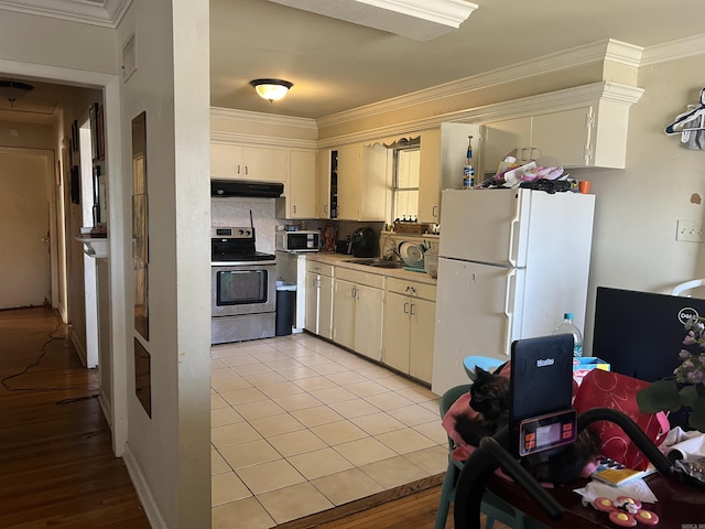 kitchen with stainless steel electric range oven, light tile patterned flooring, tasteful backsplash, white fridge, and crown molding