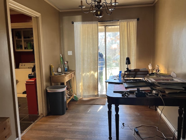 dining space featuring crown molding, wood-type flooring, washer / dryer, and a notable chandelier