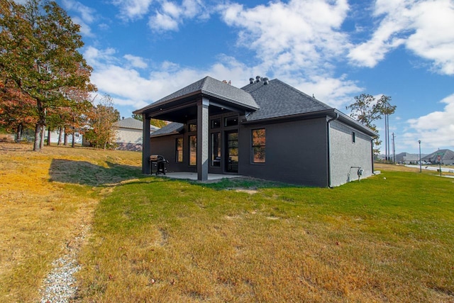 rear view of property featuring a patio and a lawn