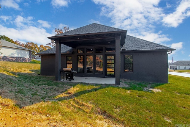 back of property featuring a patio and a yard