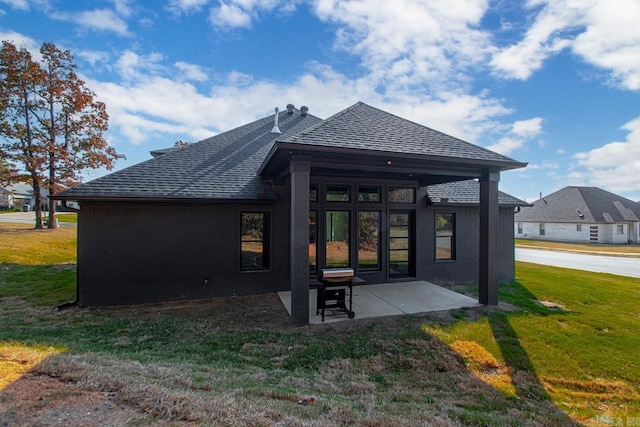 rear view of house with a yard and a patio area