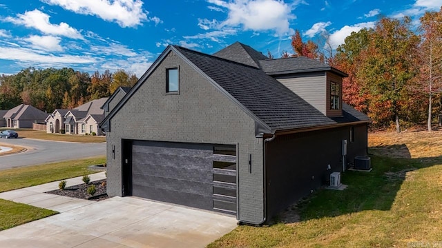 view of home's exterior featuring cooling unit, a yard, and a garage