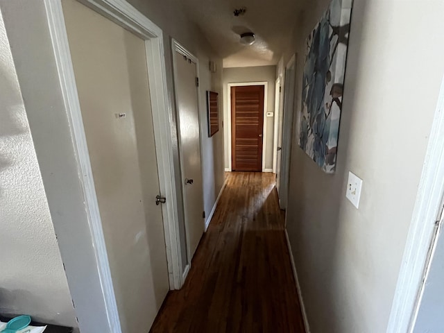 hallway with dark hardwood / wood-style flooring