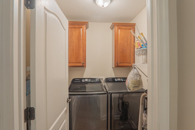 clothes washing area featuring cabinets, a textured ceiling, and independent washer and dryer