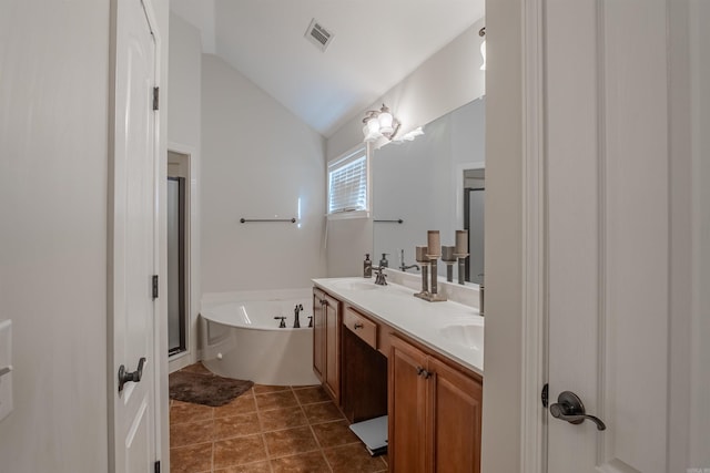 bathroom with tile patterned flooring, vanity, a tub, and lofted ceiling